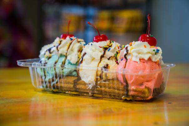 A multi-colored ice cream sundae layered on a crunchy churro