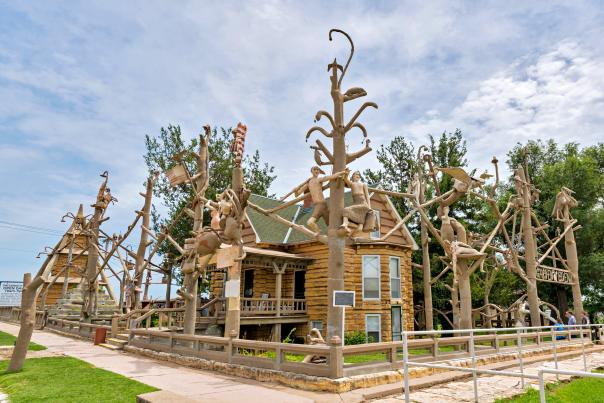 art sculptures, made out of concrete, fence around a stone cabin