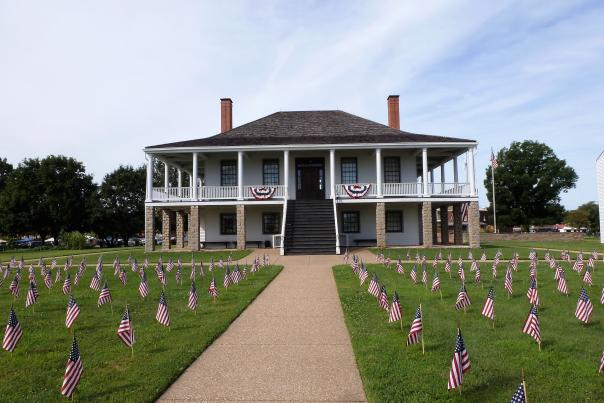 American flags line the lawn of a historic building in Fort Scott
