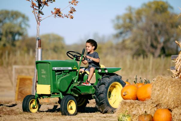 Boy riding small tractor at A&H Farms