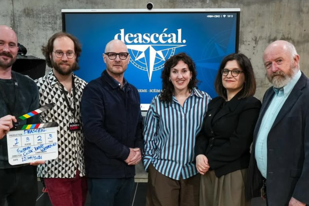 Representatives from Screen Kerry, Cork and Waterford, 4 men and 2 ladies photographed infront of a large screen with the Deasceal logo.