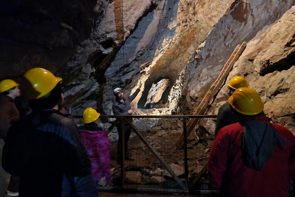 a tour guide speaks to a group in an underground mine