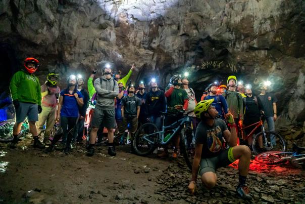 Large group of bikers pose for a photo underground at the Adventure Mine