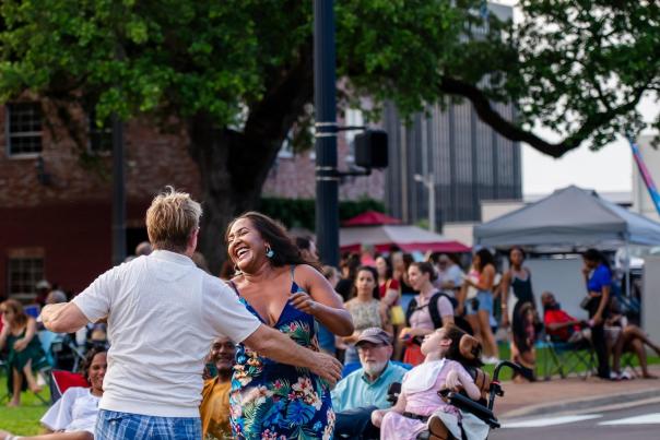 couple dancing in the street as a crowd of people watches in Downtown Lake Charles