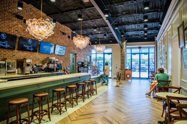 elegant light fixtures, wooden floors, green, gold, and granite bar area inside coffee:30