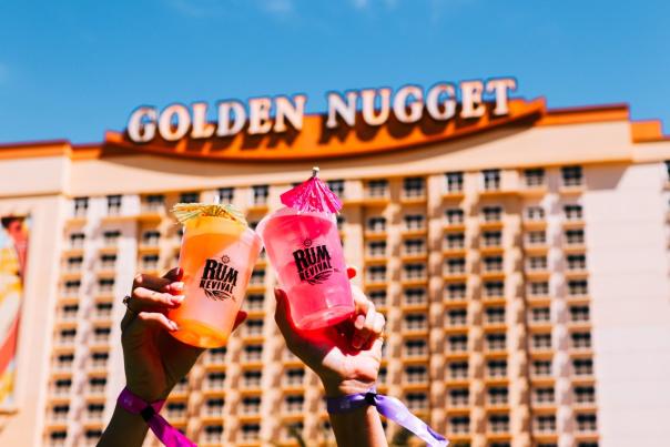 red and orange drink cups with colorful umbrellas toast in front of Golden Nugget Lake Charles