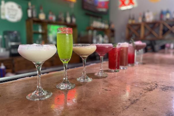 holiday drink lineup from the Terrace, white cocktail, green cocktail, brown cocktail, four burgendy cocktails, and one dark brown cocktails