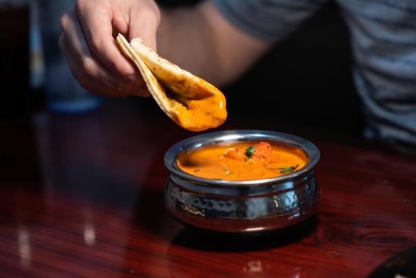bread being dipped into orange soup