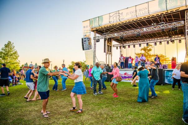 men and women dance in front of the stage at the event center amphitheater for This is Home Fest