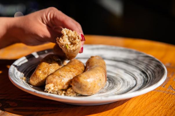 three links of boudin one held in hand