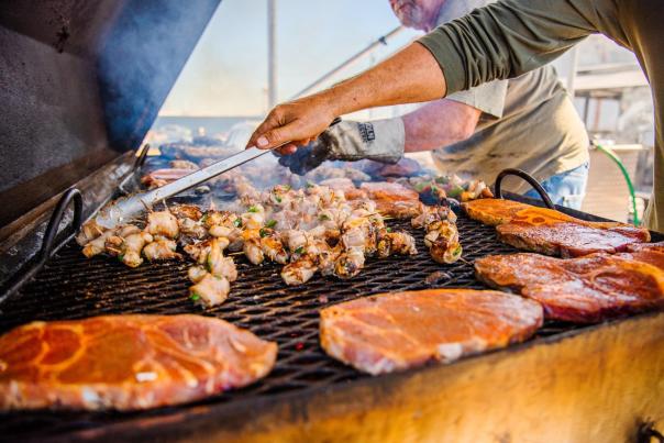 pork steaks or grillades and vegetables wrapped in bacon being grilled