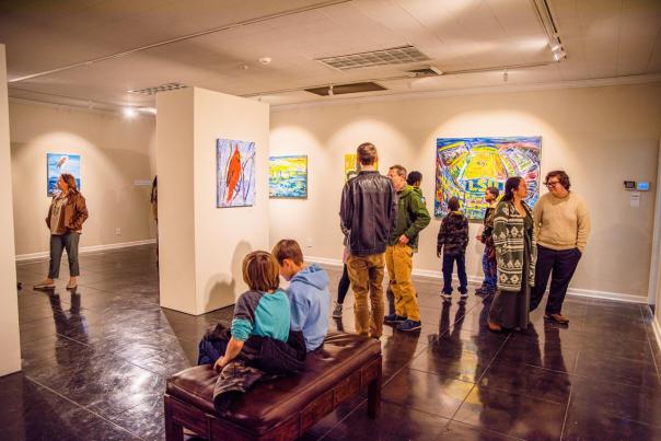 art on display being viewed by children and families