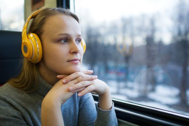Woman in headphones enjoys riding the train