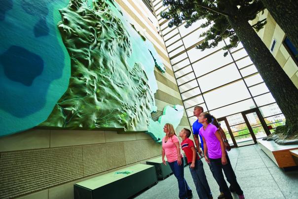 Family looking at an art piece of topographical Michigan