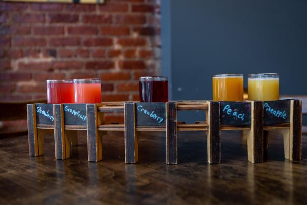 A flight of five mimosas ranging in color from orange to purple at Midtown Brewing.