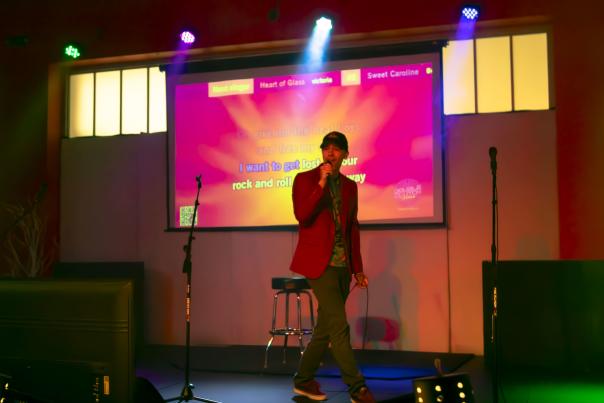 Person singing karaoke at High Caliber