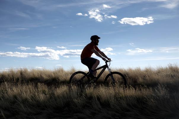 Silhouette mountain biking pilot hill with prairie grasses