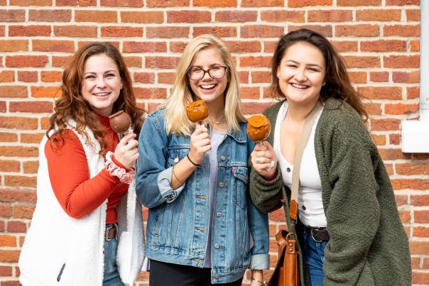 Three girls posing with caramel apples.