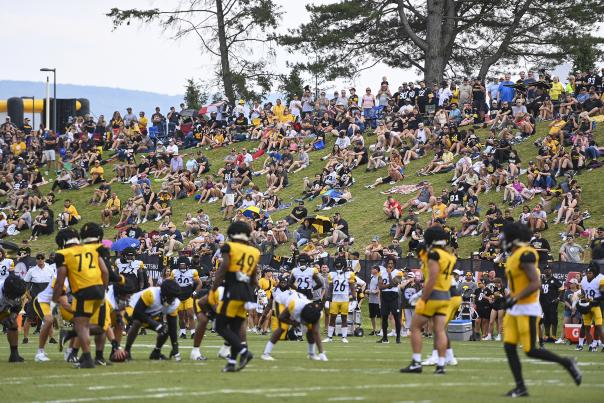 Steelers Training Camp players on field with guests in background