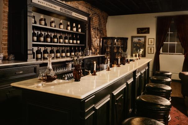 The Overholt Stateroom, a vintage-inspired lounge that pays homage to the origins of Overholt™ whiskey, features a modern bar, antique furniture and decor, vintage and modern bottlings, and a mural of Abraham Overholt.