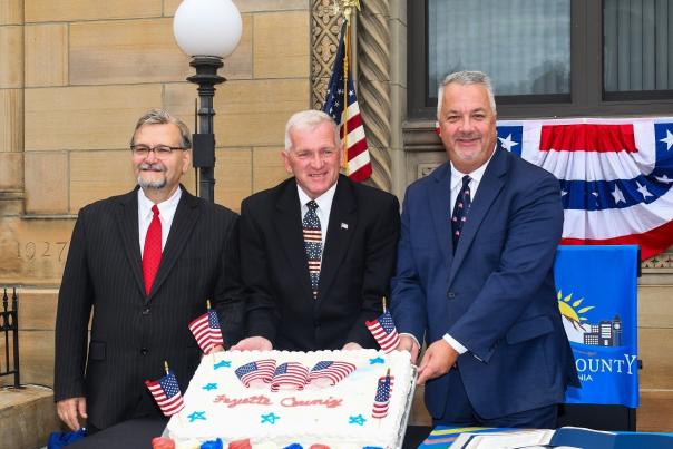 Commissioners pose with patriotic cake