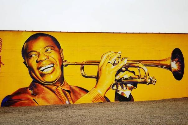 Yellow mural of Louis Armstrong playing a trumpet