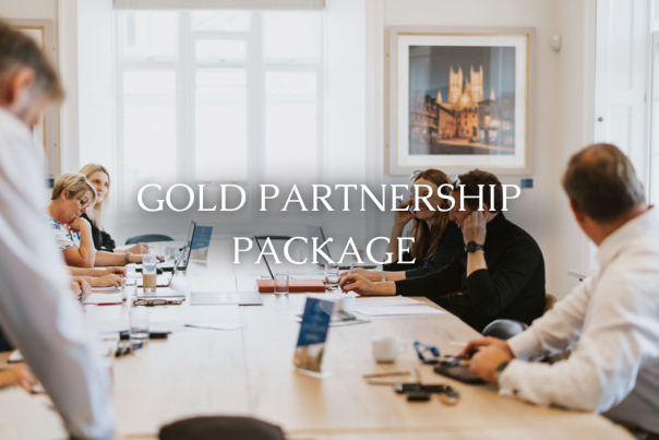 A group of business professionals sat around a long table discussing.