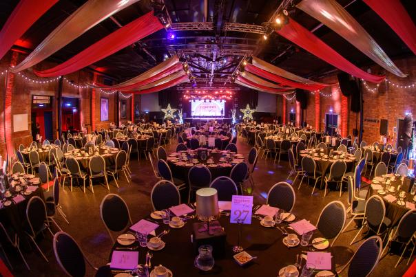 An empty conference room with tables decorated with awards celebrations.
