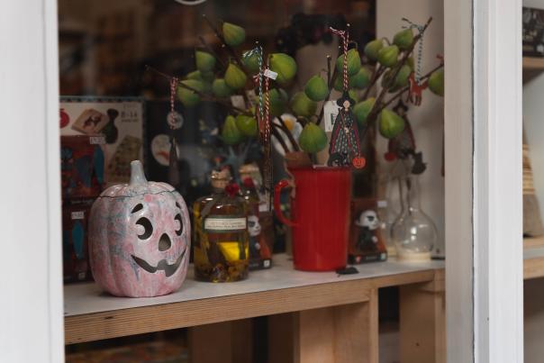 A ceramic pumpkin in the window of a shop.