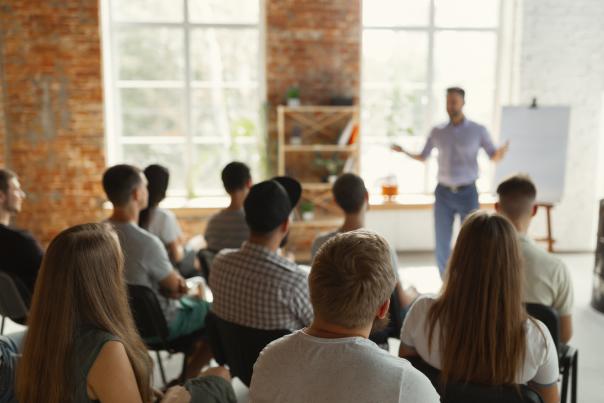 A man enthusiastically presenting infront of a group of people