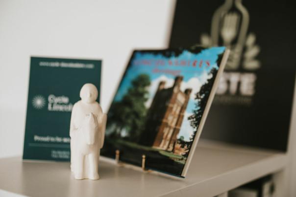 A clay knight on a horse in front of a selection of leaflets on a table