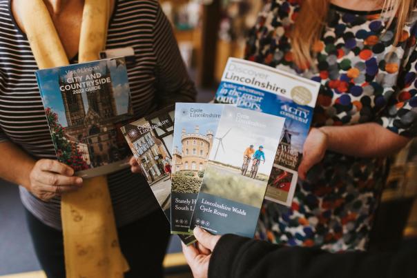 people stood together holding a selection of brochures, leaflets and guides
