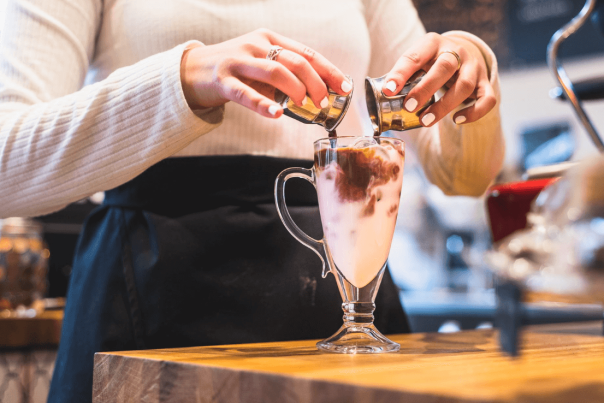 woman pouring chocolate into a glass of milk