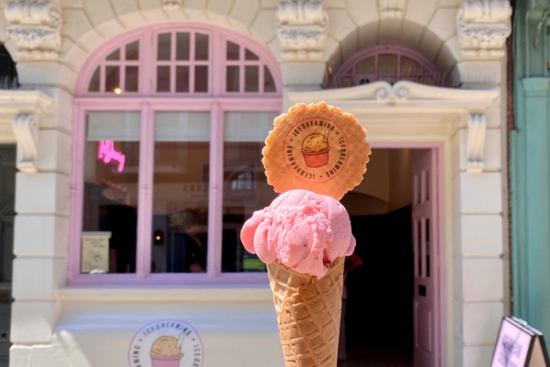 Ice cream cone being held up outside of an ice cream shop in Lincoln