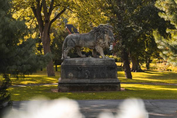 a view of a lion statue in Lincoln's Arboretum