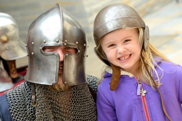 An image of a cosplaying medieval soldier and a young girl