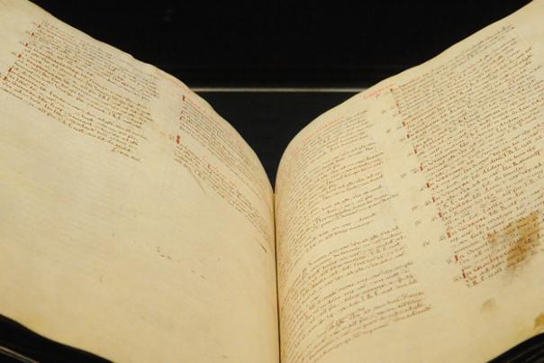 picture of the Domesday Book opened with small, scribed writing on each apge
