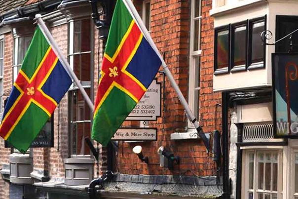 Two Lincoln flags hanging on the wall outside houses