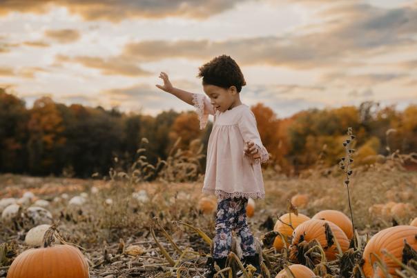 Girl Walking through Pumpkin Patch