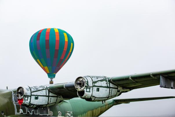 Green plane in front of hot air balloon
