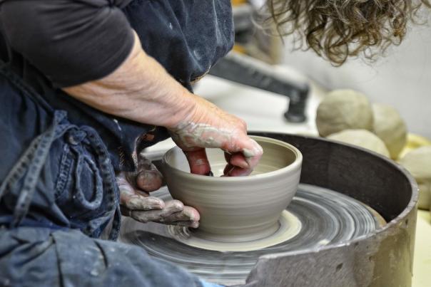 Woman making bowl at potters wheel