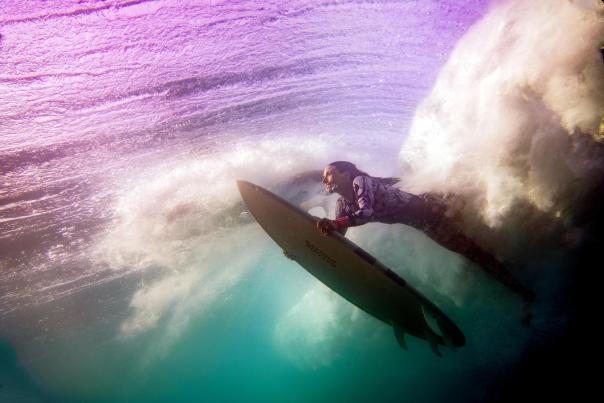 fotografía por debajo del agua de una mujer surfista