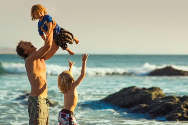 padre e hijos jugando en una playa en los cabos