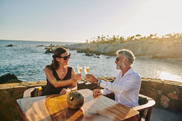 pareja heterosexual bebiendo vino en un restaurante con vista al mar