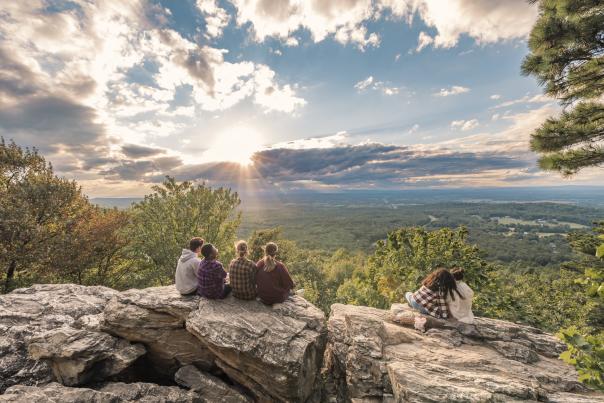 Friends watching the sunset from the rock at Bears Den Overlook in Bluemont, Loudoun