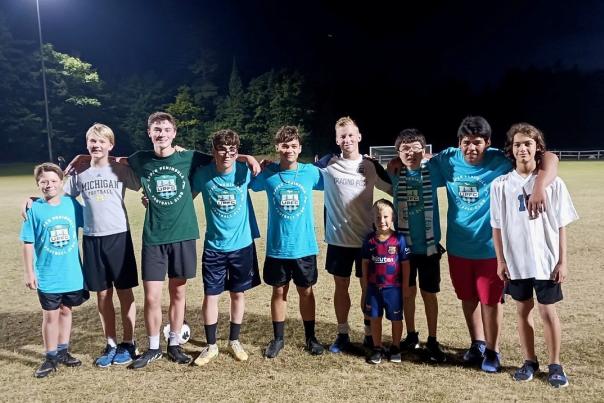 A group of Mackinac Island kids pose under the lights after a soccer game in Great Turtle Park