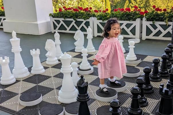 A little girl stands in the middle of a giant chess board on the front porch of Mackinac Island’s Grand Hotel