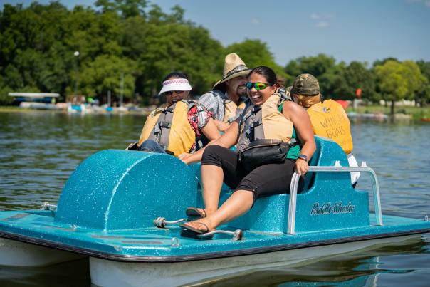 A group of four people enjoy Madison's lakes via a paddle boat