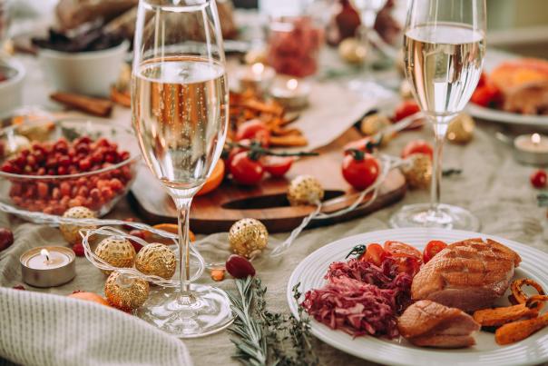 A holiday dinner table setting with glasses of champagne