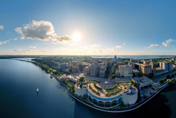 A wide drone image of the city at sunset with Monona Terrace in the foreground